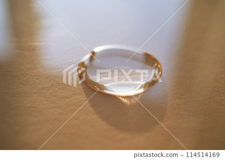 Beautiful volumetric drop of cosmetic product on a beige background. Beautiful volumetric drop of cosmetic product on a beige background. 114514169