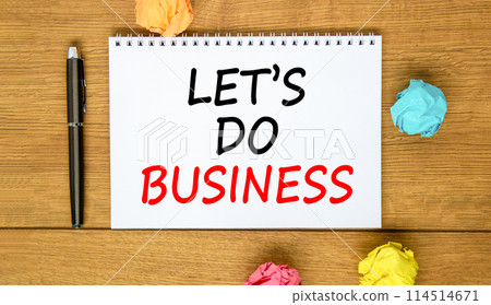 let is do business symbol. Concept words let is do business on beautiful white note. Beautiful wooden background. Black pen. Colored paper. let is do business concept. Copy space. 114514671