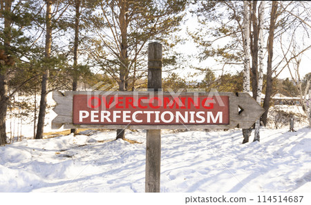 Overcoming perfectionism symbol. Concept words Overcoming perfectionism on beautiful wooden road sign. Beautiful winter forest snow background. Business Overcoming perfectionism concept. Copy space. 114514687