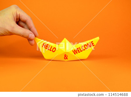Hello and welcome symbol. Concept words Hello and welcome on beautiful yellow paper boat. Beautiful orange background. Businessman hand. Business hello and welcome concept. Copy space. 114514688
