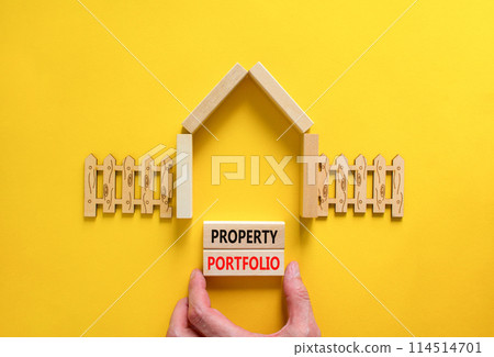 Property portfolio symbol. Concept words Property portfolio on beautiful wooden blocks. Model of house. Businessman hand. Beautiful yellow background. Business Property portfolio concept. Copy space. Property portfolio symbol. Concept words Property portfolio on beautiful wooden blocks. Model of house. Businessman hand. Beautiful yellow background. Business Property portfolio concept. Copy space. 114514701