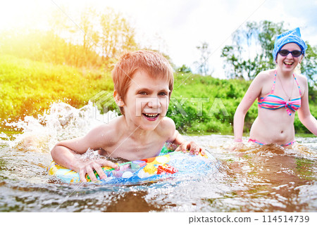 Children bathes in river on summer day 114514739