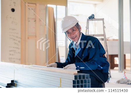 A carpenter checking materials at a construction site A carpenter checking materials at a construction site 114515430