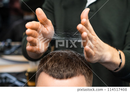 Hairdresser adjusts freshly cut hair of client in barbershop closeup. Careful stylist tousles haircut serving man in grooming salon Hairdresser adjusts freshly cut hair of client in barbershop closeup. Careful stylist tousles haircut serving man in grooming salon 114517408