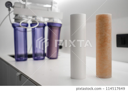Used dirty filters for cleaning water on the table and system for reversed osmosis on the background. Used dirty filters for cleaning water on the table and system for reversed osmosis on the background. 114517649