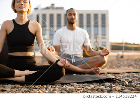 Close up view of hands on knees of young couple in sportswear. 114518224