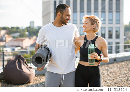 Portrait of young couple doing sports outside house on urban background of city. 114518324