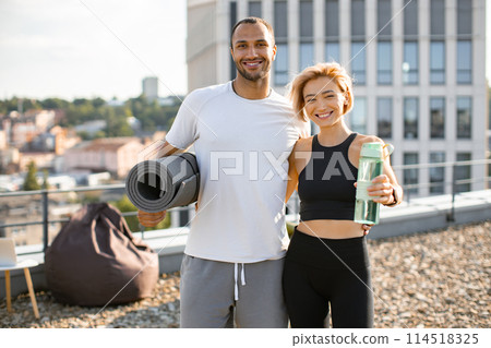 Portrait of young couple doing sports outside house on urban background of city. 114518325