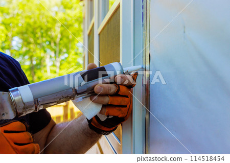 After windows have been installed, seams are coated with silicone, seals are stripped 114518454