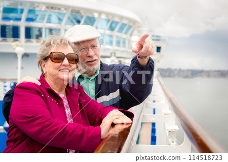 Senior Adult Couple Enjoying The View From Their Passenger Cruise Ship Railing. 114518723