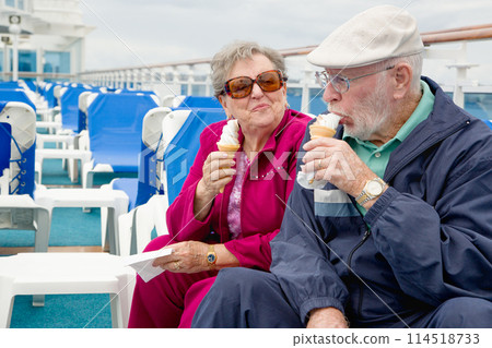 Happy Senior Adult Couple Enjoying Ice Cream On The Deck of a Luxury Passenger Cruise Ship. 114518733
