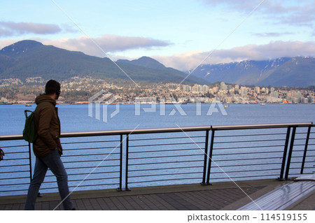 A person looking at north Vancouver from downtown seawall 114519155