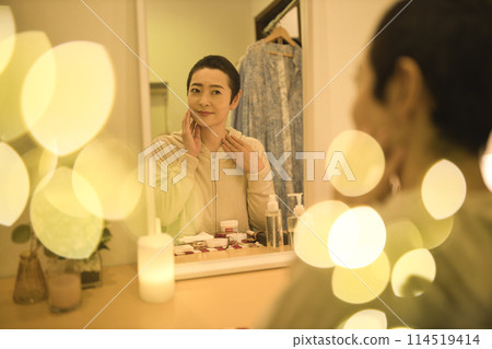 Middle-aged woman doing night skin care Middle-aged woman doing night skin care 114519414