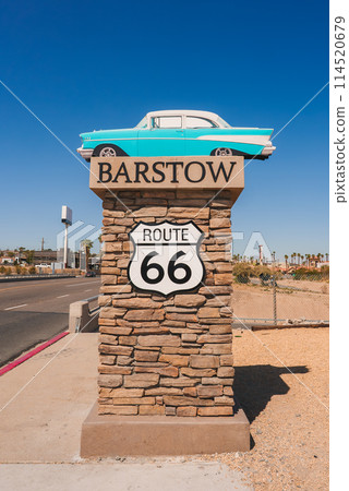 Explore a revealing monument highlighting Barstow on Route 66, USA. Stone base, BARSTOW and ROUTE 66 texts, classic car, clear sky, desert backdrop. Explore a revealing monument highlighting Barstow on Route 66, USA. Stone base, BARSTOW and ROUTE 66 texts, classic car, clear sky, desert backdrop. 114520679