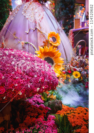 Vibrant floral display in Las Vegas venue with red roses, sunflowers, and colorful blooms creating a lush, festive atmosphere. Rich composition indoors with elaborate decorations. 114520682