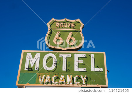 Vintage motel sign featuring iconic Route 66 design against blue sky in Barstow, USA. Classic mid 20th century roadside advertising with nostalgic charm. 114521405