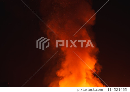 Vibrant burst of fire against dark background resembling night sky. Bright orange flames transition to mix of colors. Perfect for festivals in desert settings. 114521465