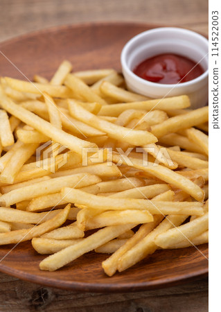 French fries and ketchup on a wooden table 114522003