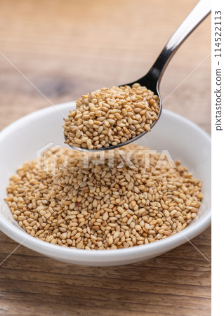 Scoop white sesame seeds with a spoon 114522113