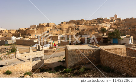 Ancient houses on hillside with mosque minaret in Tamezret village 114522863