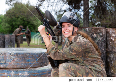 Portrait of girl in camouflage on paintball field Portrait of girl in camouflage on paintball field 114522868