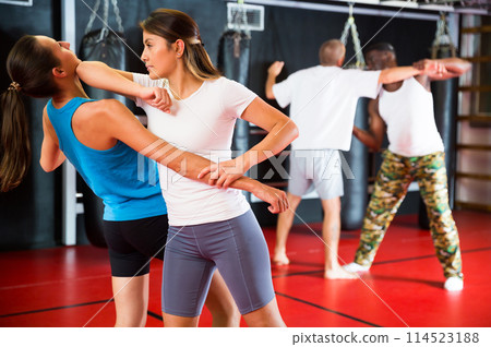 Two woman is training on self defense course in gym Two woman is training on self defense course in gym 114523188
