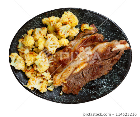 Lunch for restaurant guest - fried fatty and juicy lamb and vegetable side dish of cauliflower 114523216