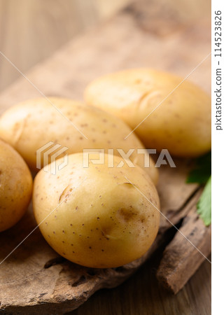 Raw potatoes on wooden background, Food ingredient 114523826