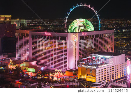 Vibrant night view of Las Vegas Strip. Features Flamingo Hotel and Casino, LINQ, High Roller observation wheel, neon lights, urban landscape. Capture city nightlife essence. 114524445
