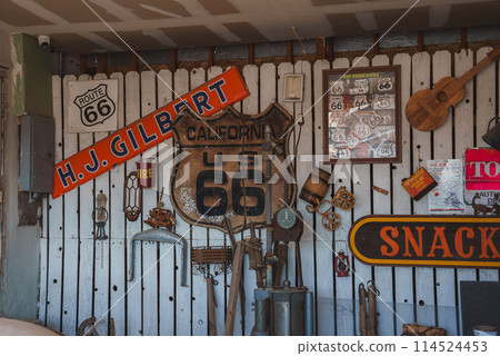 Vintage Americana collection featuring iconic Route 66 memorabilia, including road signs, antique tools, and nostalgic items at a location in Barstow, USA. 114524453
