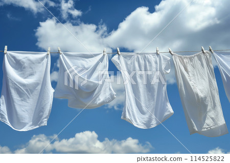 A white shirt hanging out to dry in the blue sky 114525822