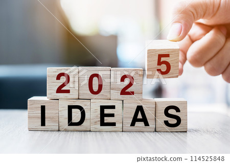 Businessman hand holding wooden cube with flip over block 2024 to 2025 Plans word on table background. Resolution, strategy, solution, goal, business and New Year holiday concepts 114525848