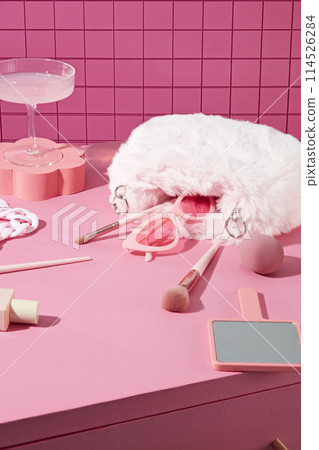 High angle shot at some lifestyle pink items flat lay on pink cabinet including makeup utensils, glasses, mirror and so on. Blank space in center for displaying product, copy space High angle shot at some lifestyle pink items flat lay on pink cabinet including makeup utensils, glasses, mirror and so on. Blank space in center for displaying product, copy space 114526284