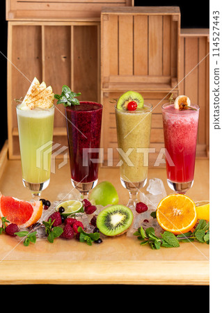 Group of fresh healthy fruit smoothies at wooden table background with ingredients around. 114527443
