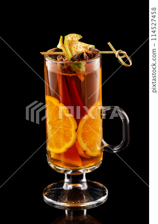 Closeup cup of tea with orange and cinnamon isolated at black background. Closeup cup of tea with orange and cinnamon isolated at black background. 114527458