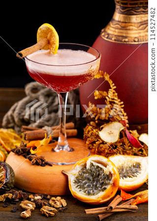 Vertical image of glass of cosmopolitan cocktail at decorated wooden table background with free space. 114527482