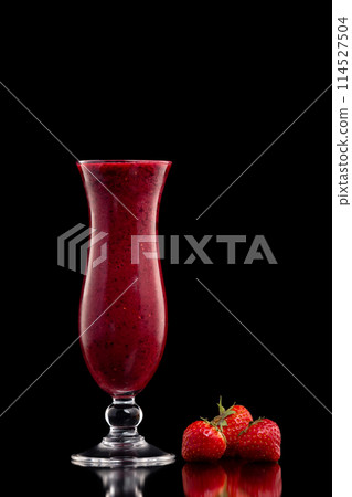 Glass of red currant berries fresh shake decorated with strawberries isolated at black background. Glass of red currant berries fresh shake decorated with strawberries isolated at black background. 114527504