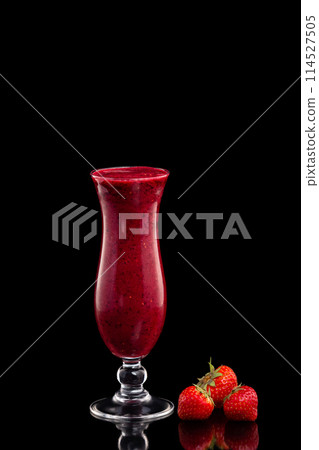 Glass of cherry fresh shake decorated with strawberries isolated at black background. Glass of cherry fresh shake decorated with strawberries isolated at black background. 114527505