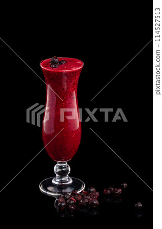 Glass of red currant berries fresh shake decorated with black currant isolated at black background. 114527513