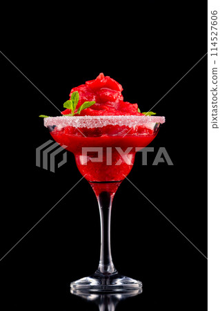 Closeup glass of red daiquiri strawberry cocktail decorated with mint isolated at black background. Closeup glass of red daiquiri strawberry cocktail decorated with mint isolated at black background. 114527606