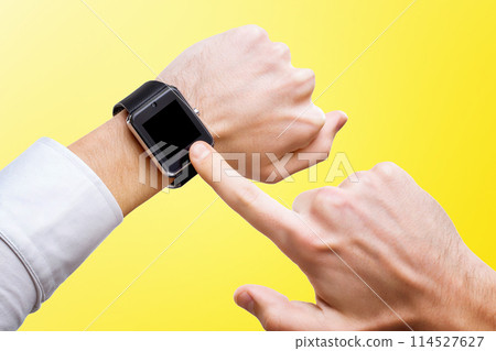 Businessman is pointing at smart hand with smart watch isolated at yellow background. 114527627