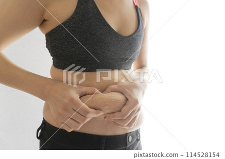 A woman pinching her belly fat that still has stretch marks after giving birth 114528154