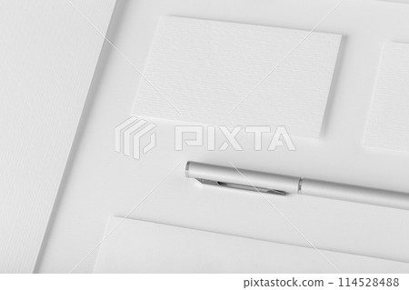 Corporate stationery set mockup. Presentation folder, envelope and business cards at white textured background. Corporate stationery set mockup. Presentation folder, envelope and business cards at white textured background. 114528488