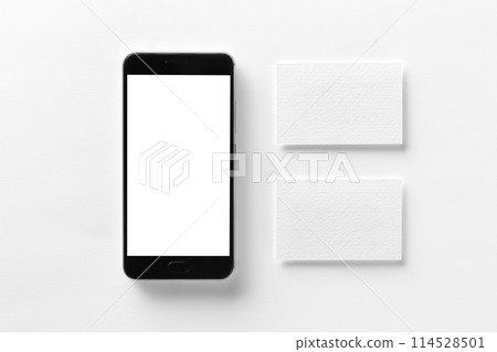 Mockup of cellphone with blank screen and business cards isolated at white paper. 114528501