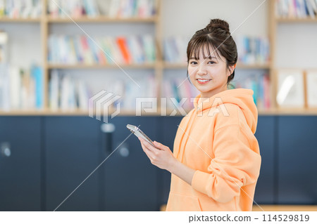 操作智慧型手機的大學生。 114529819