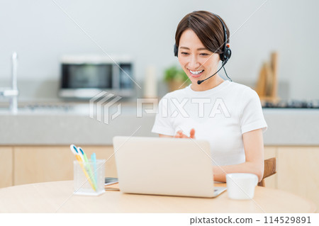 在客廳遠程辦公的中年婦女。 在客廳遠程辦公的中年婦女。 114529891