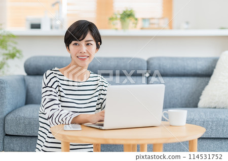 一位女士在客廳使用電腦。 114531752