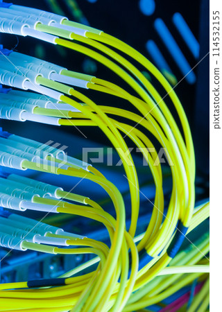 fiber optic cables plugged in network switch panel inside data center 114532155
