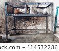 The iron table that houses the trader's stove looks dirty, the table has been used for annual trading 114532286