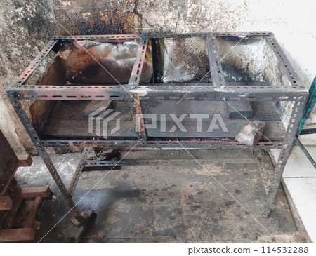 The iron table that houses the trader's stove looks dirty, the table has been used for annual trading The iron table that houses the trader's stove looks dirty, the table has been used for annual trading 114532288